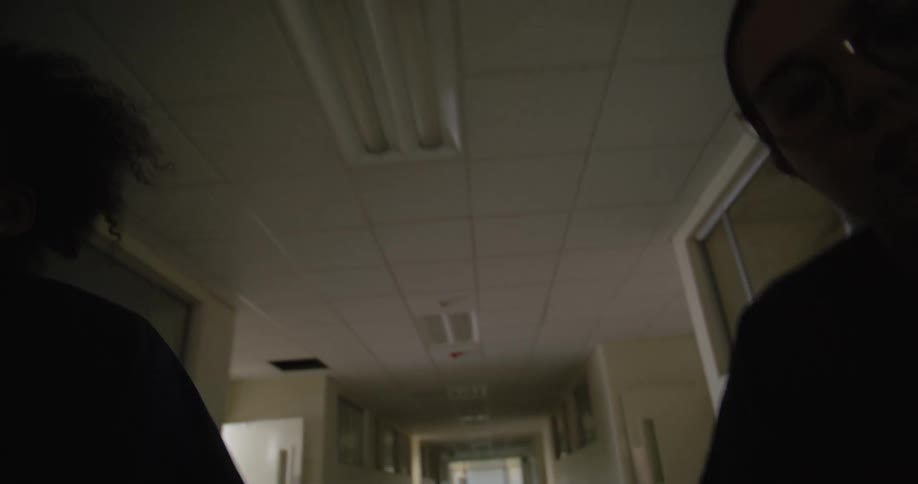 Two hospital workers travel down the hallway