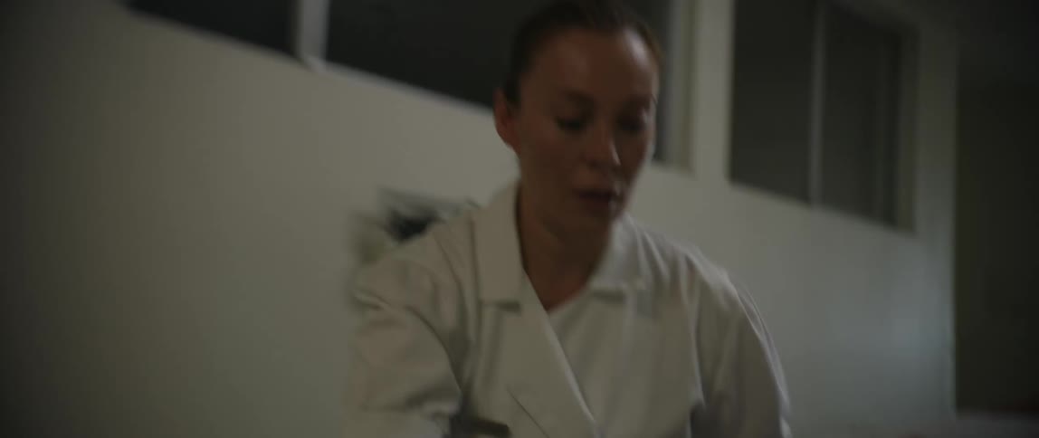 A woman is running while pushing a gurney through the hospital