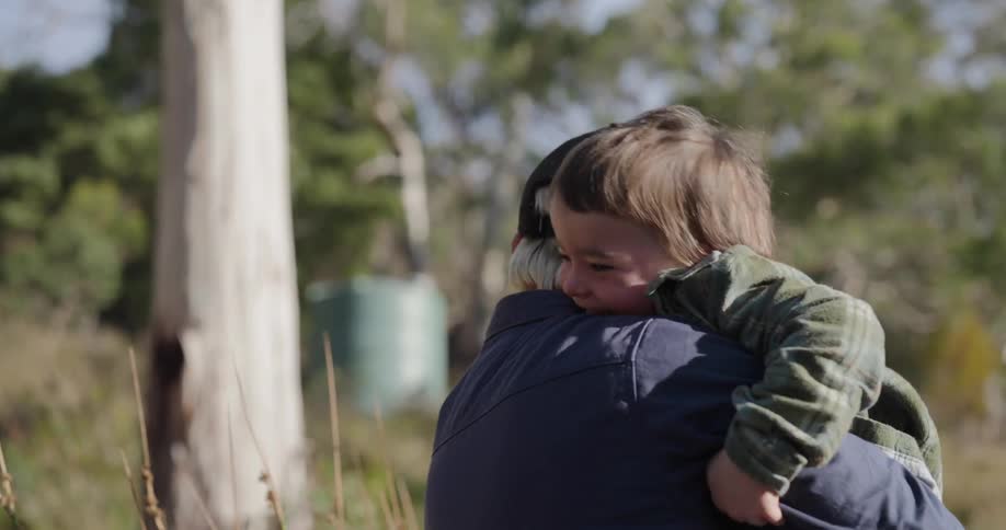 A child running toward their father and giving him a tight hug