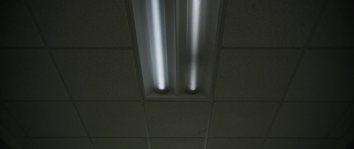 Tube lights flickering on ceiling lights in building
