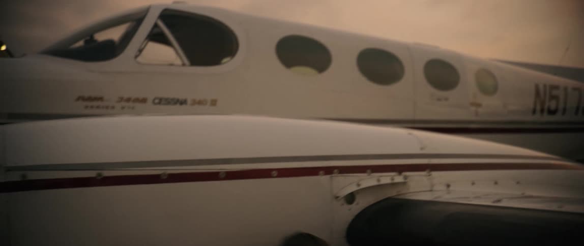 A man doing maintenance on an airplane at sunset