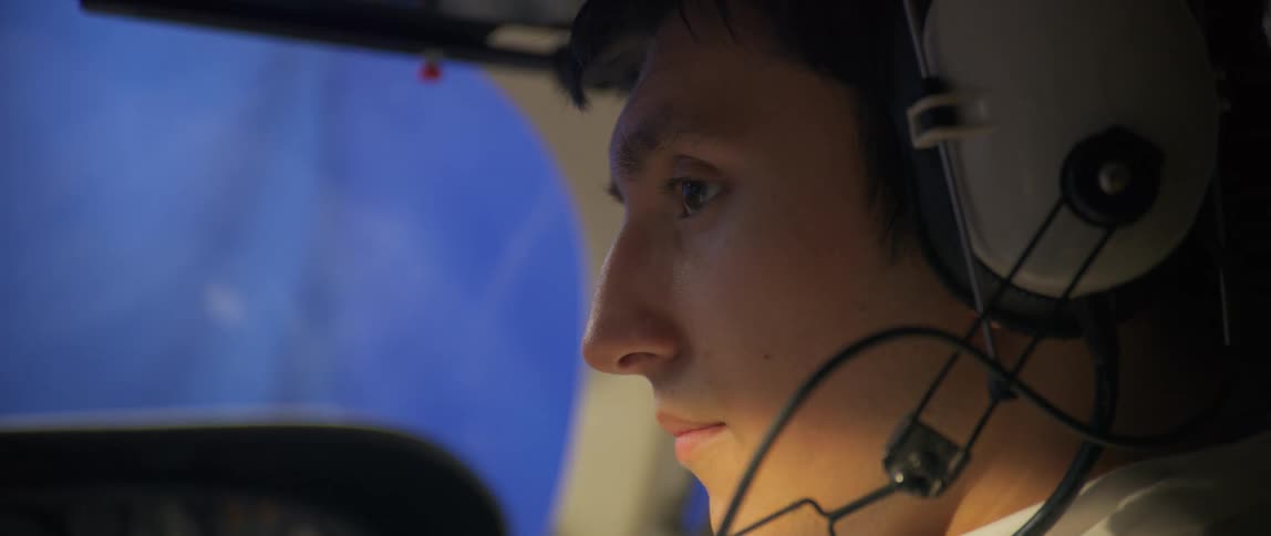 Side portrait of a man in an airplane cabin with headphones on