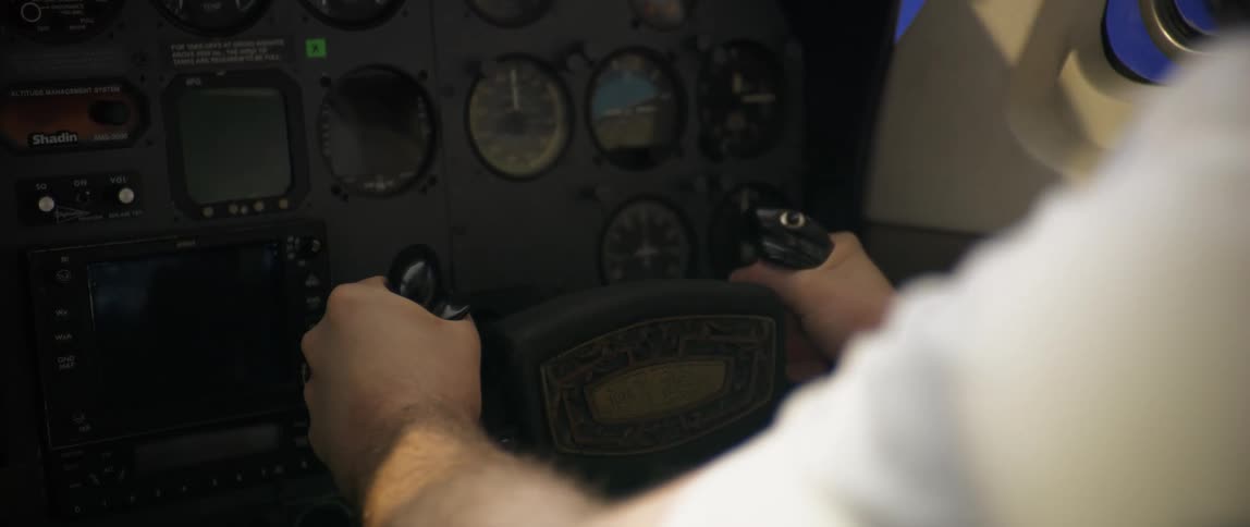A man pulls back on the steering wheel in the plane