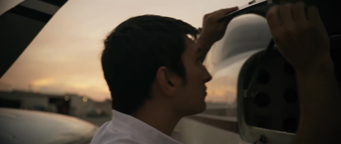 Man briefly opens the cargo space of a small plane parked on the tarmac