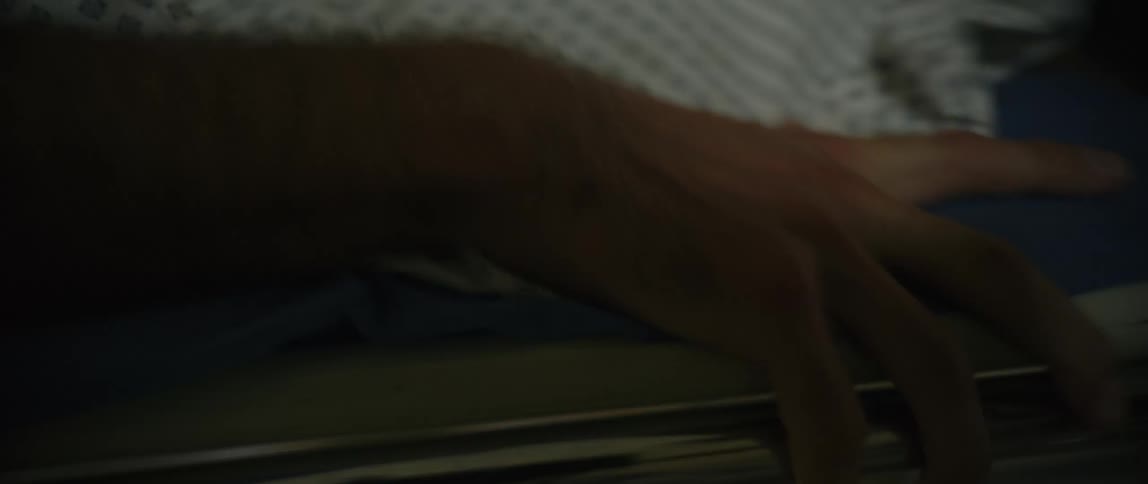 A patient grips the edge of a gurney
