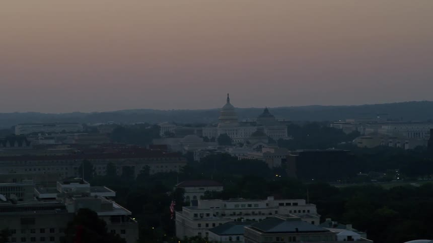 The sun is setting over this city on a cloudy day