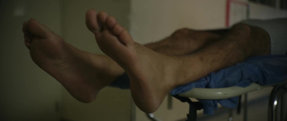 A patient is wheeled on a stretcher along the hospital corridors