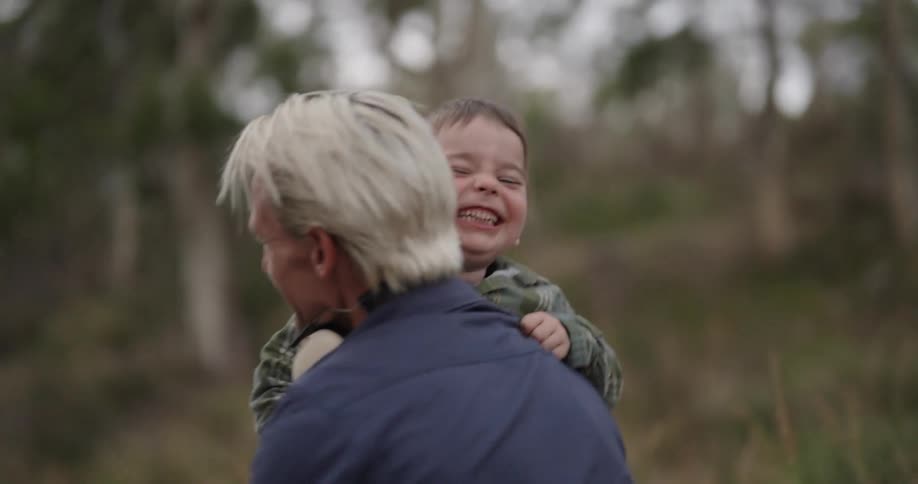 Father and son hugging in a natural environment with happy expression