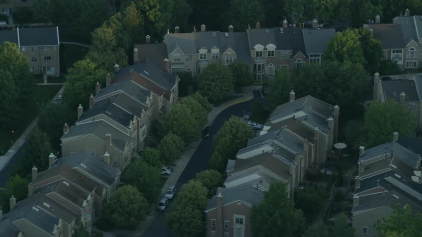 Tops of houses and streets surrounded by trees in neighborhood