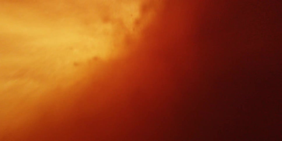 An extremely bright orange tunnel of fire and magma with sparks bursting past the lens