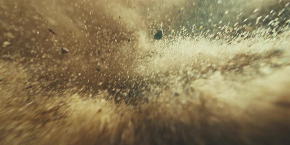 Debris and clouds of dust fly through the air during a cataclysm