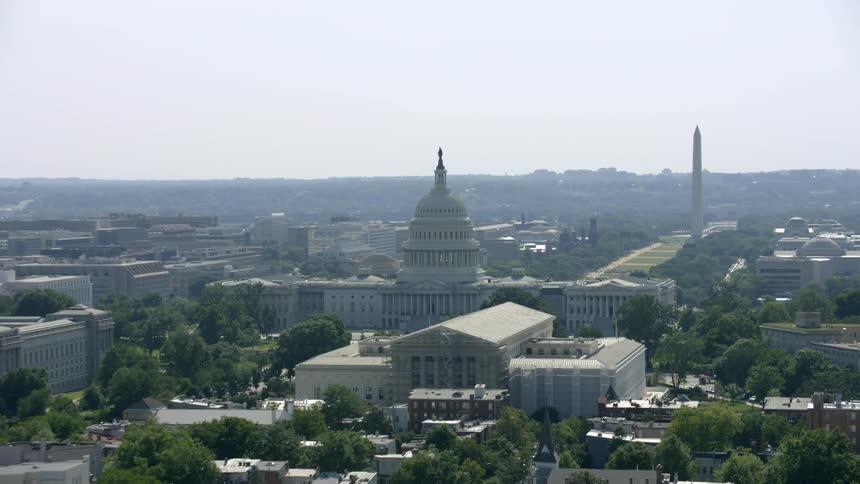The city has many buildings and a pillar in the distance
