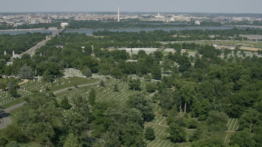 A large cemetery lined with trees is below