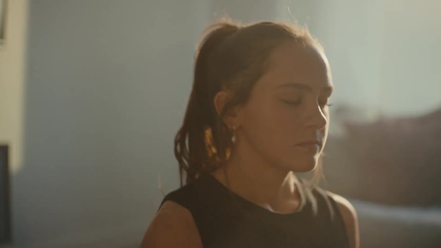 Sunshine shines on a womans face that is meditating