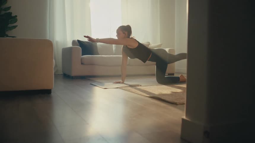 A woman is doing yoga in her living room