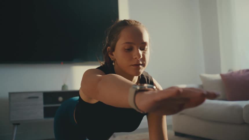A woman is doing yoga by the couch