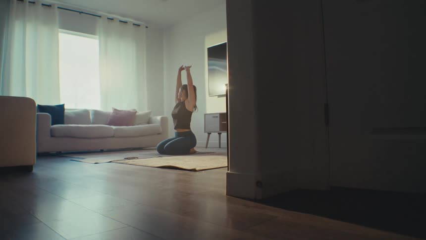 A woman practicing yoga in a living room