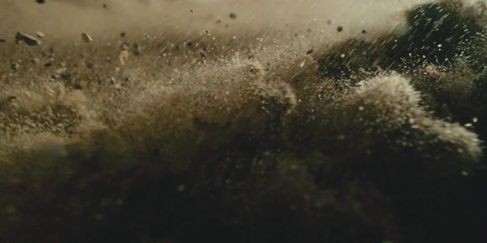 Circling a Sand Explosion as Debris and Dust Burst Outward