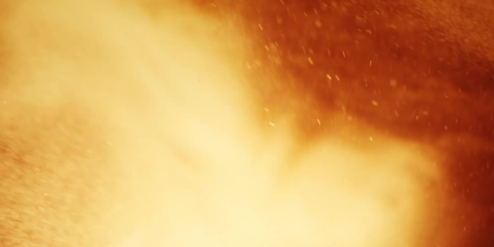 A dynamic closeup of swirling orange and yellow particles showing the reaction created during nuclear fission