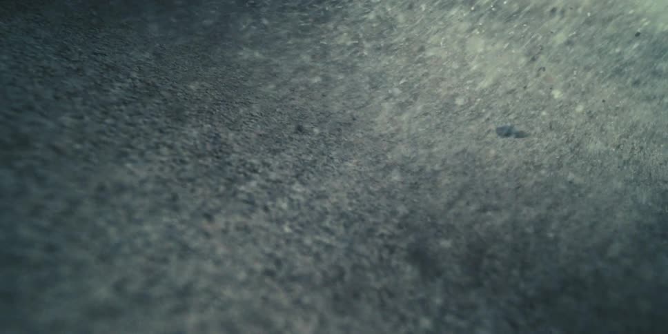 A wave causes sand to disperse with force at the bottom of the sea