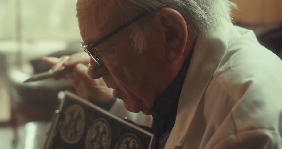 A doctor closely examines brain scan images on a clipboard likely reviewing or discussing a medical diagnosis