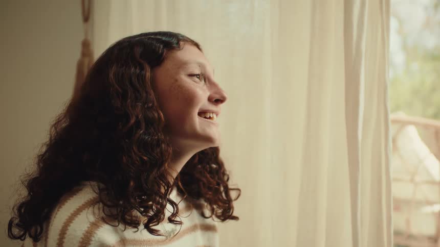 Two women laugh as they have a conversation in a room