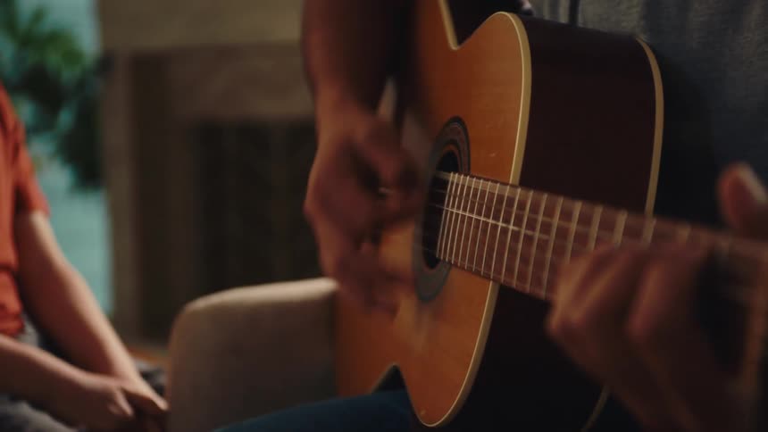 A child is singing while a man plays guitar