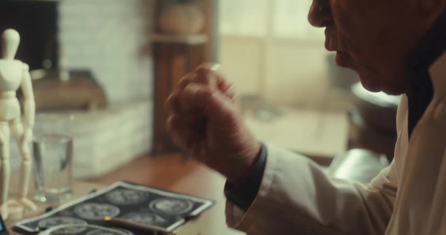 A man sits in a virtual meeting pointing and shaking his hands as he appears to explain something