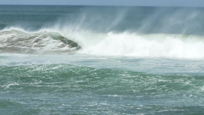 Ocean waves spraying water on a sunny day