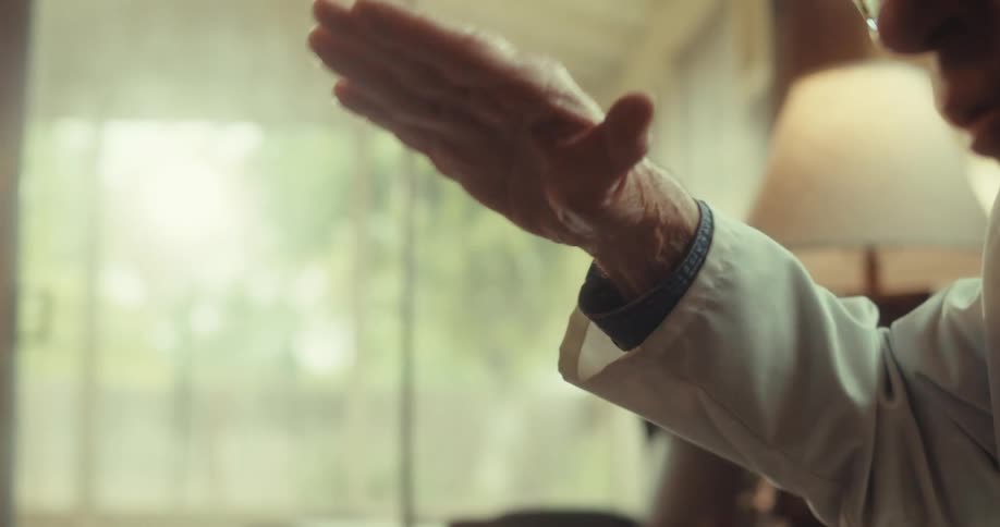 Doctor gestures while giving an explanation during a home healthcare visit