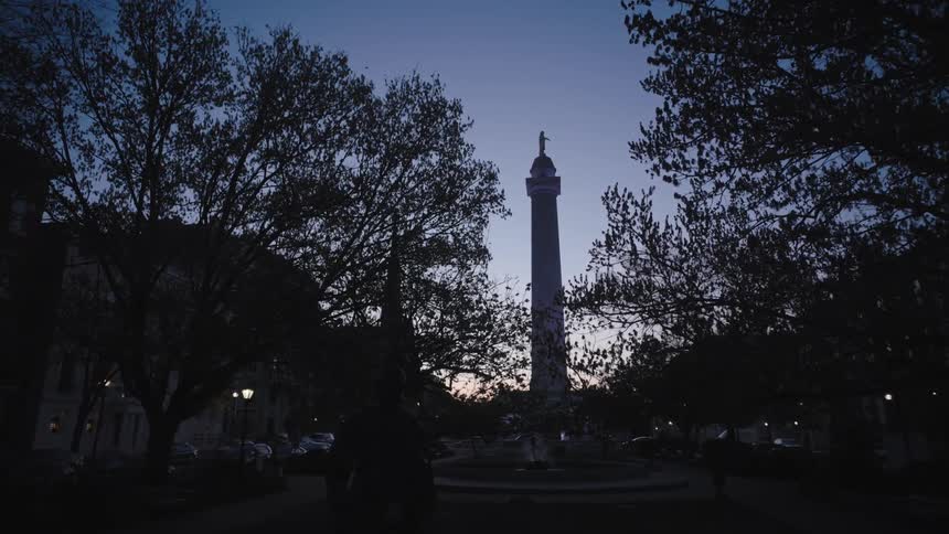 A tall tower is in the middle of the round about