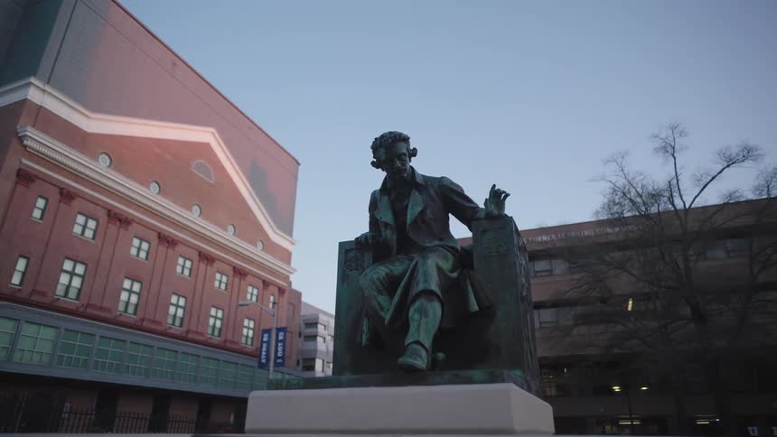A statue is on a concrete base in a city square