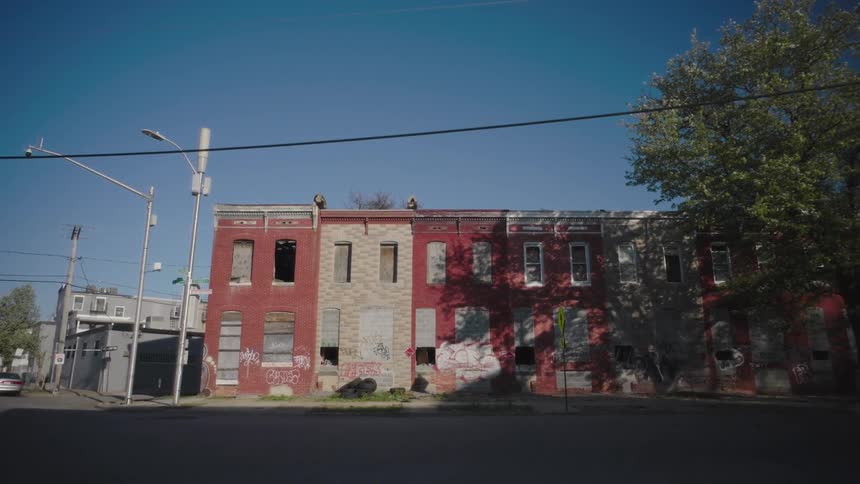The apartment buildings are on the corner are all boarded up