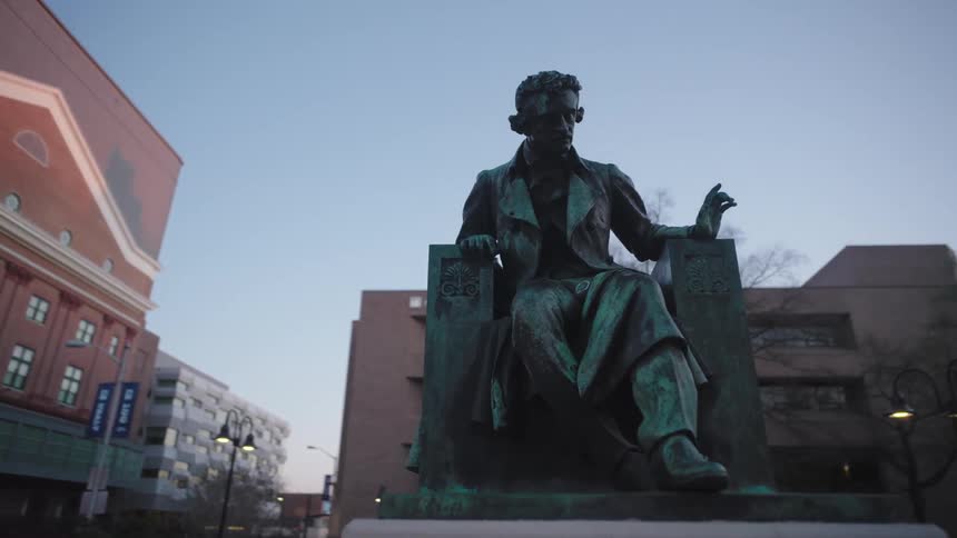 Statue of a man sitting in an armchair in a square in the city