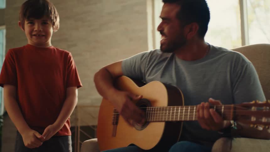An image of a man playing a guitar with a kid