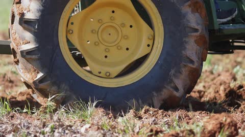 A farm vehicle slowly works the field