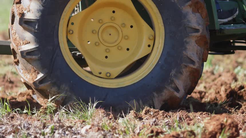 A farm vehicle slowly works the field