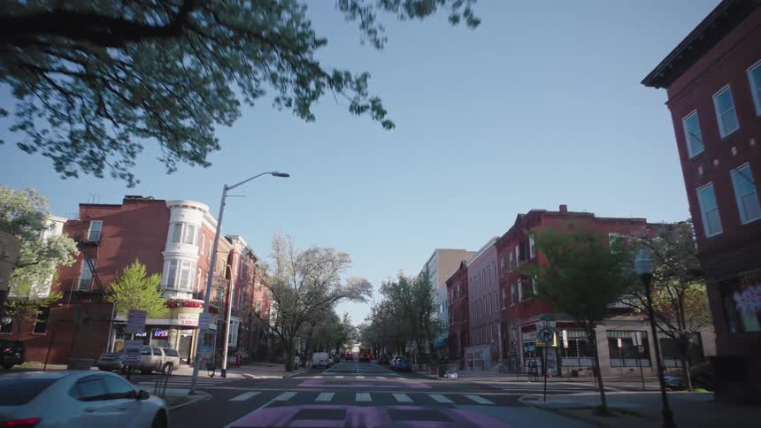 Moving view through the streets of an urban city during a cloudless blue sky day