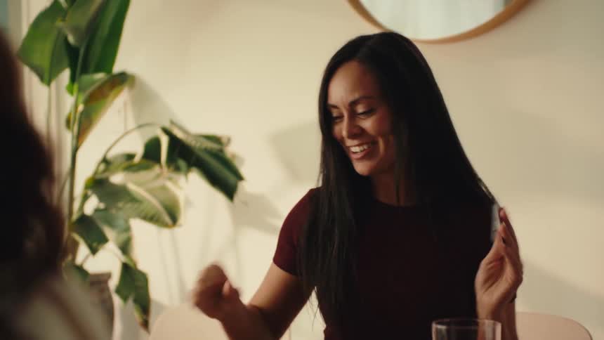 A woman rolls the dice onto the table and cheers