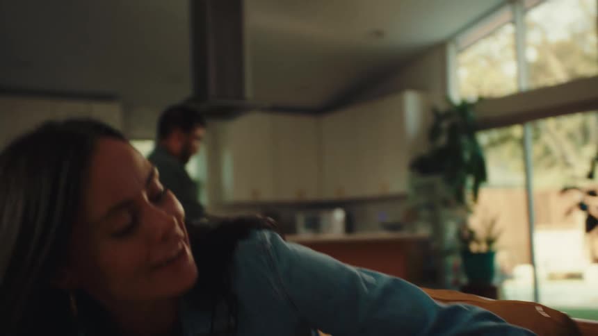 A footage of a mother sitting beside her children in the living room