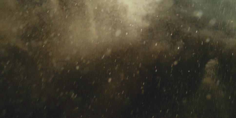 A slowmotion macro shot of particles or debris suspended in air creating a dynamic and textured abstract visual