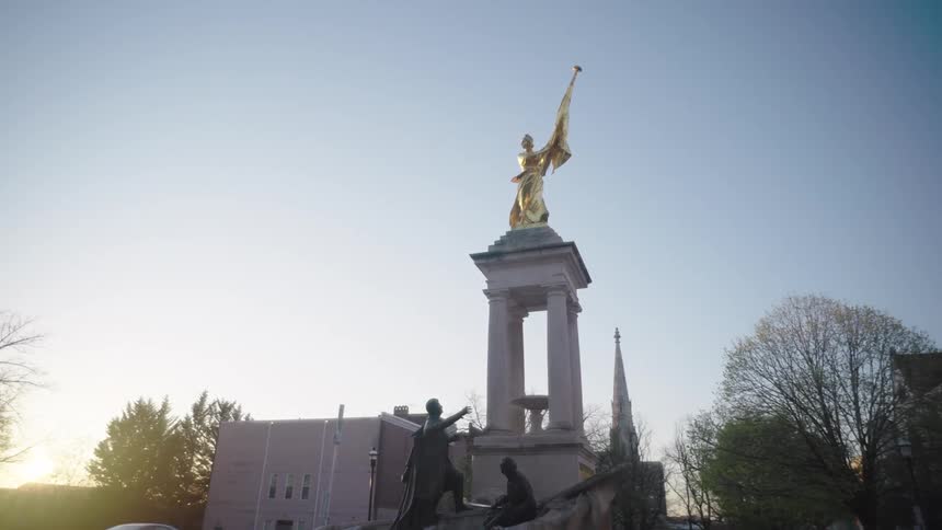 A car drives past the monument in the city