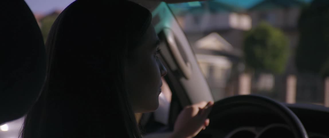 A woman is driving her car through a city