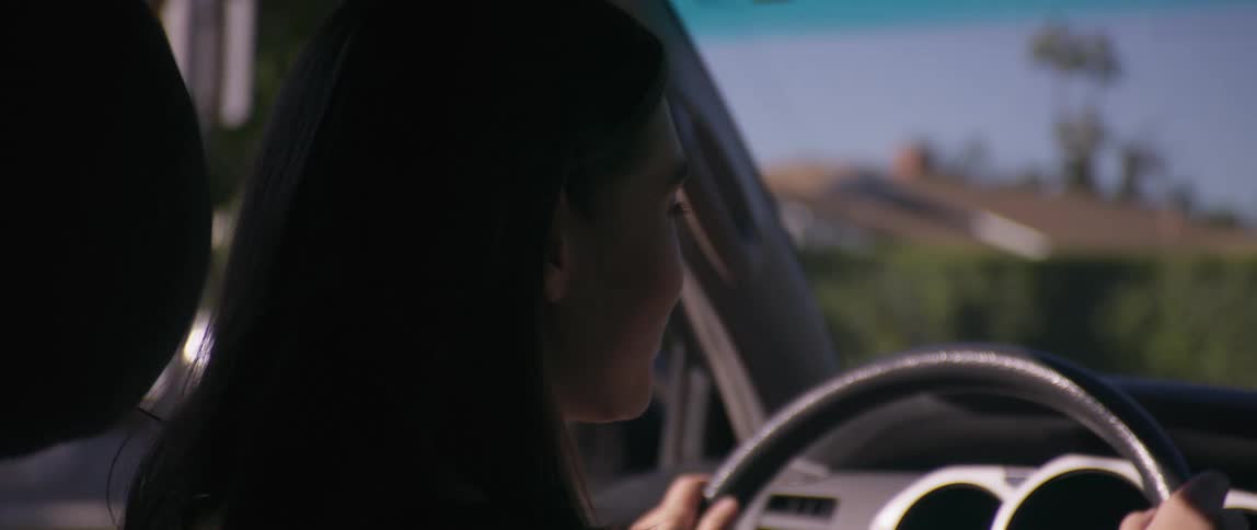 A woman is driving through a neighborhood