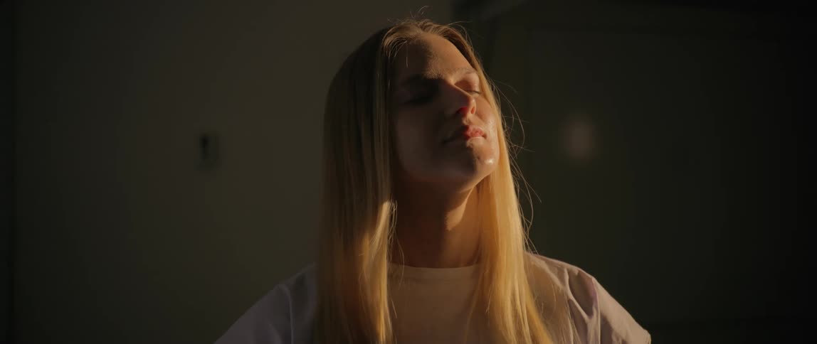 The woman smiles as the sunlight hits her face