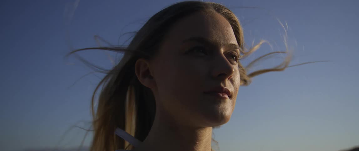 Woman with blonde hair blowing in the wind relaxing