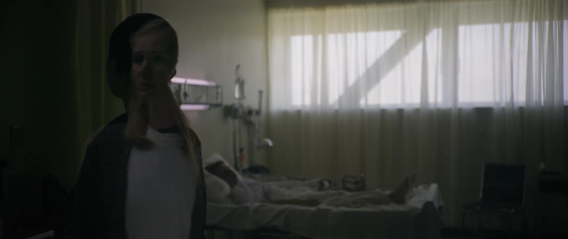 A female nurse checking a man on the hospital bed during the day