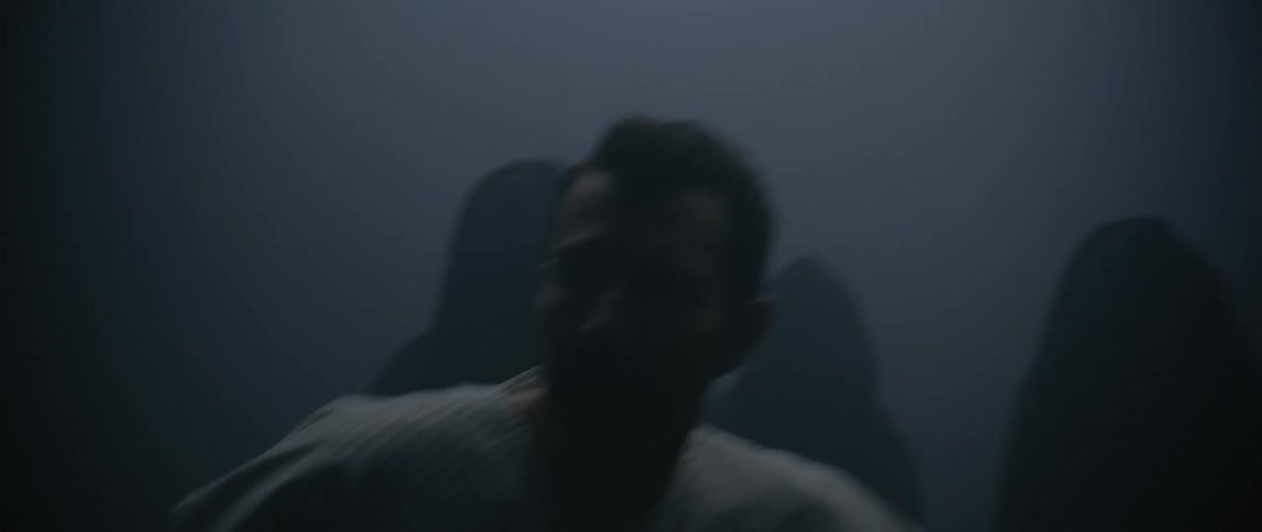 A hospital patient is pushed around by a group of people in dark robes