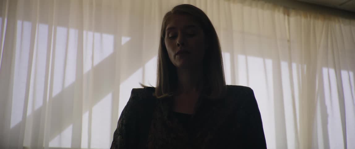 The woman is talking by the window
