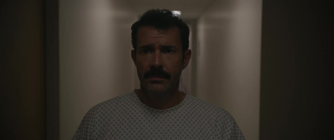 The lights quickly shut off in the hallway of the hospital as the man turns